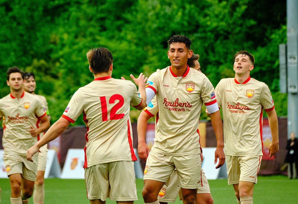 Ballard FC players celebrate after a good play in a 2022 match