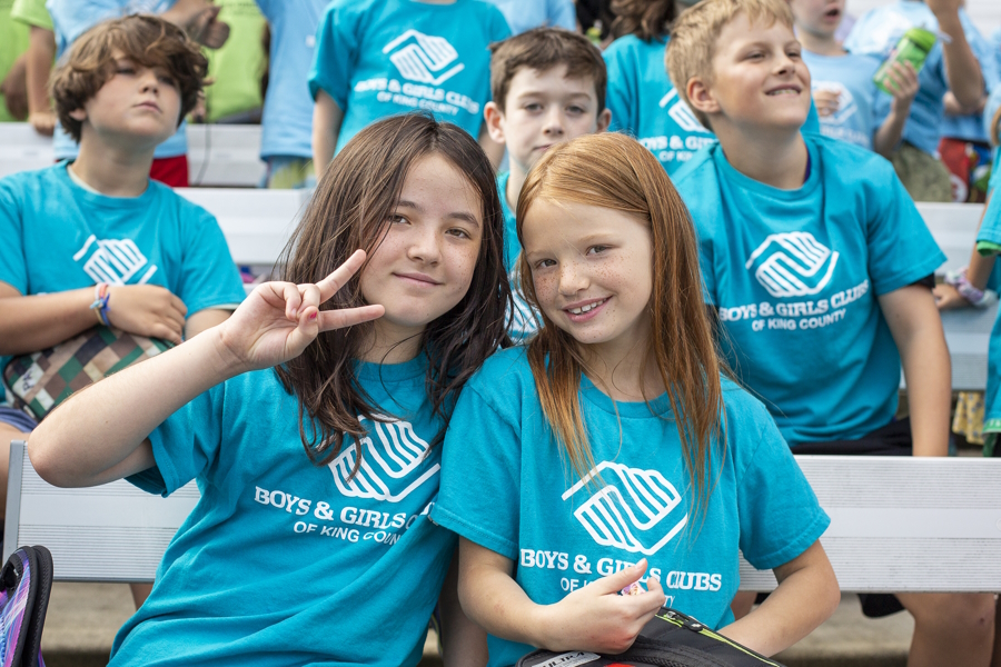 two girls in blue Boys and Girls clubs shirts smiling at the camera