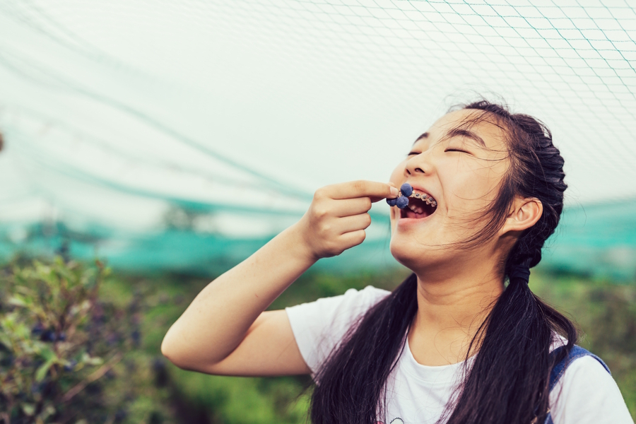 Teen girl eating blueberries