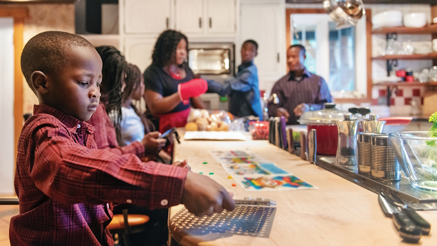Child doing a Thanksgiving activity while parents cook