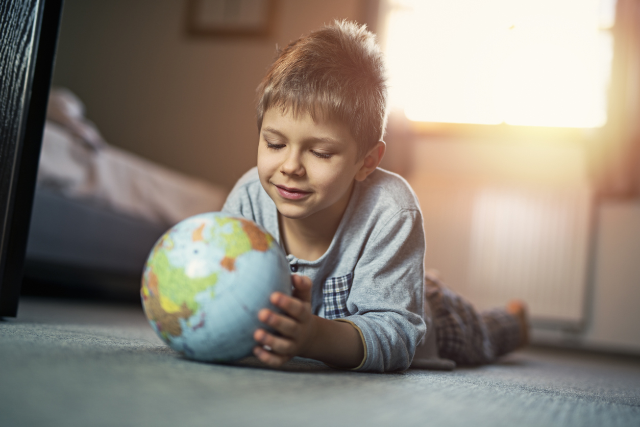 little boy looking at a globe