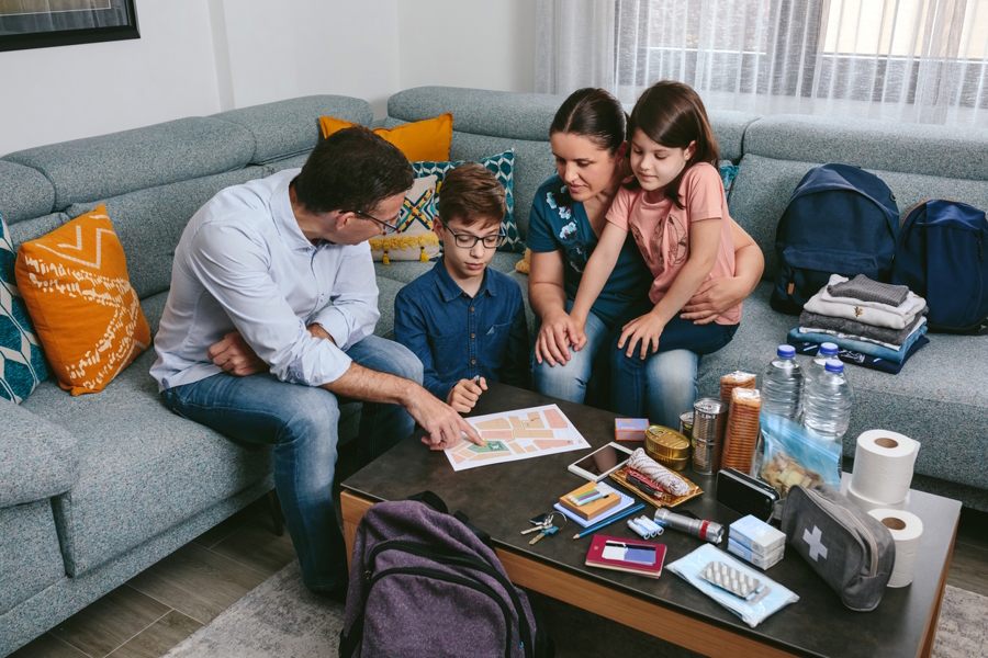 a family sitting around a coffee table going over emergency plans