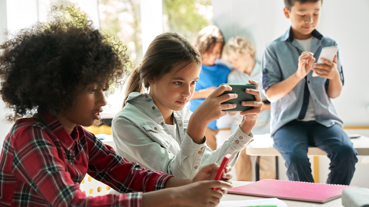 Kids using their cell phones in the classroom at school
