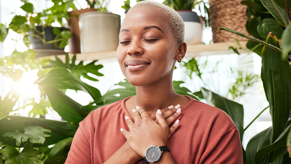 woman with eyes closed and hands over her heart breathing deeply