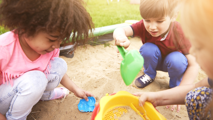 Kids playing in a sandbox at an eco-friendly birthday party