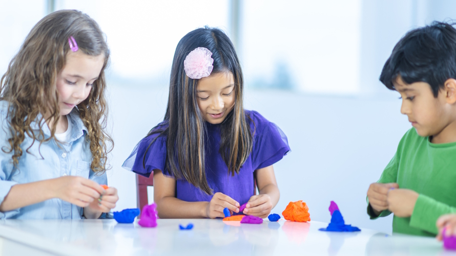 Kids playing with play dough at an eco-friendly birthday party
