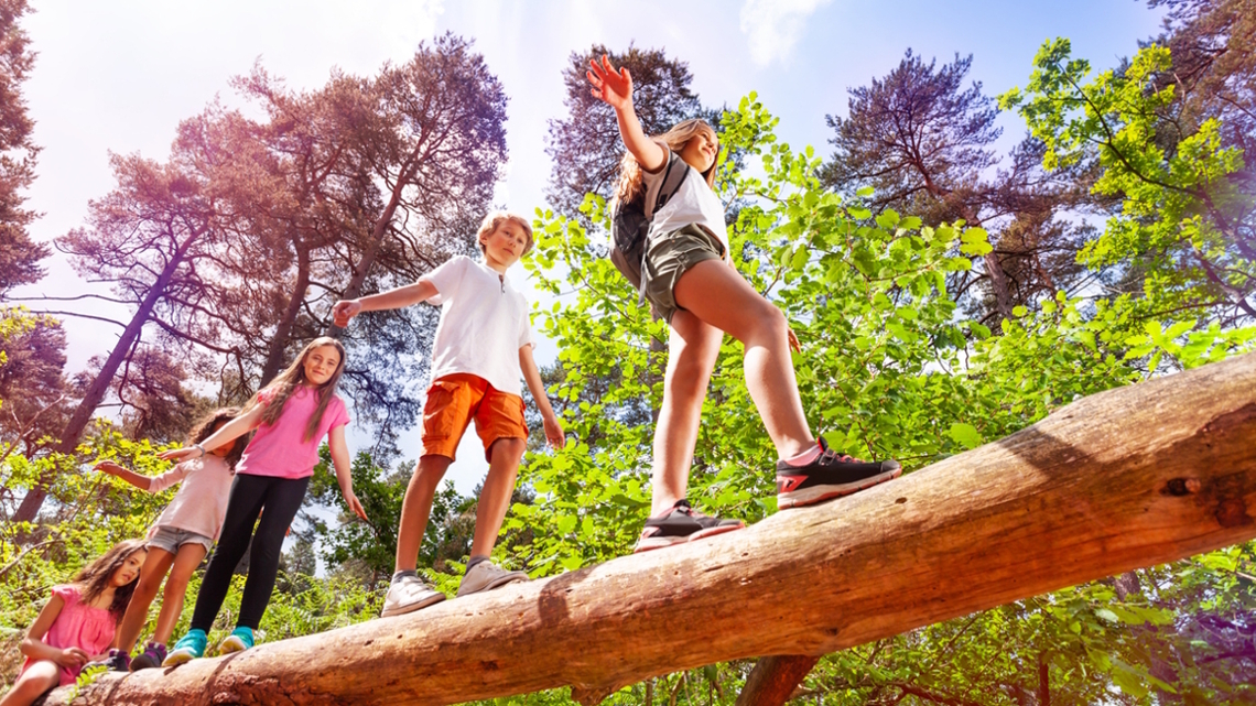 kids walking across a log at summer camp