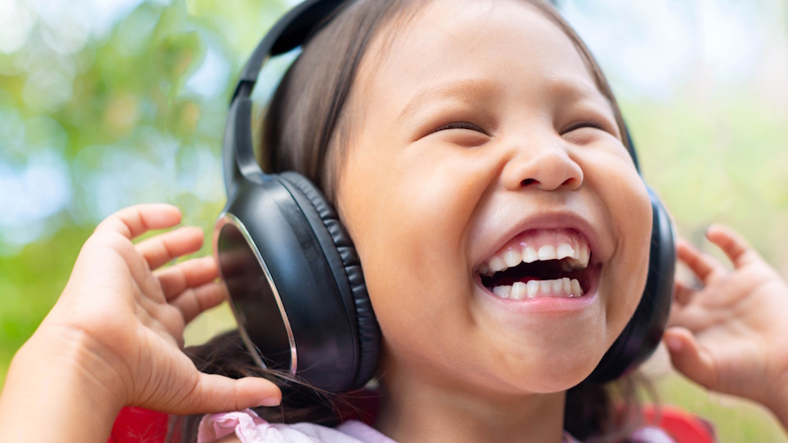 Young girl with a big smile wearing headphones