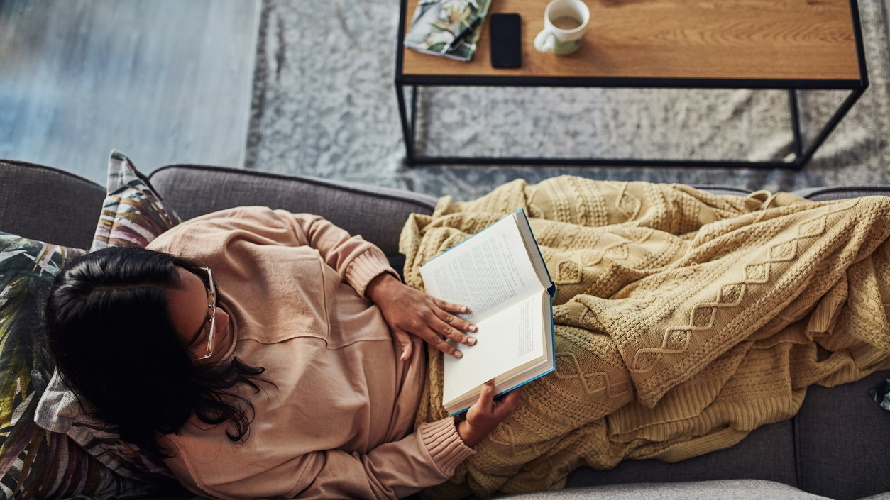 Woman-reading-a-book-on-sofa