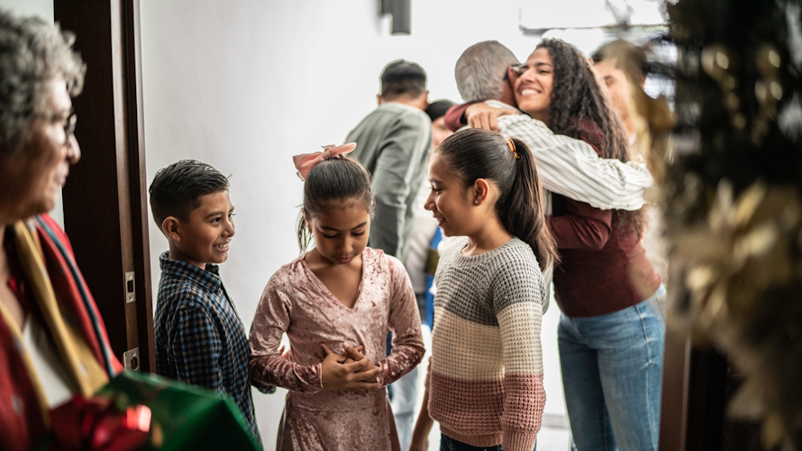 Family hugging and greeting as they arrive for a holiday celebration