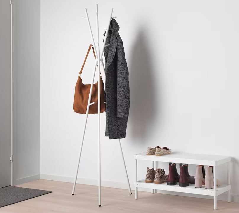 Coat stand holding coat and bag near a shoe rack in an entryway