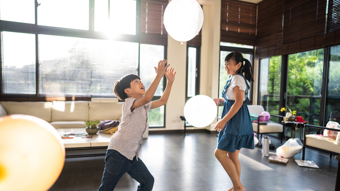 kids playing with balloons in their house