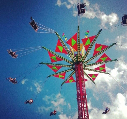 Kids in a big swing in high against a blue sky in Puyallup