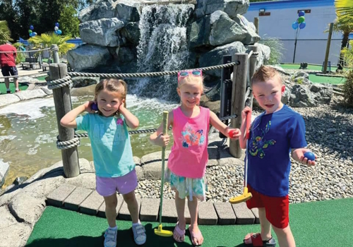 Three kids playing mini golf in Puyallup