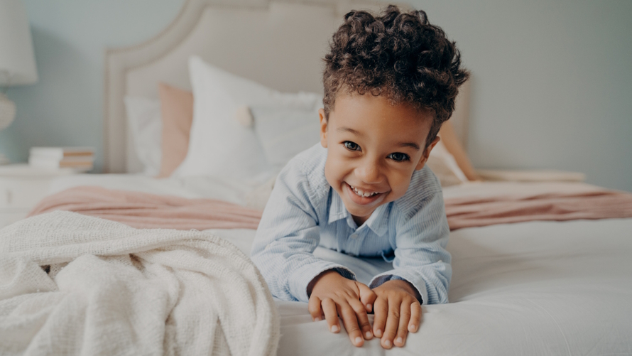 Child in a bed happy about getting better sleep