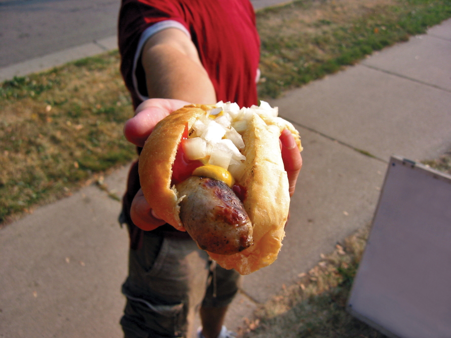 Child's hand holding a wurst dog