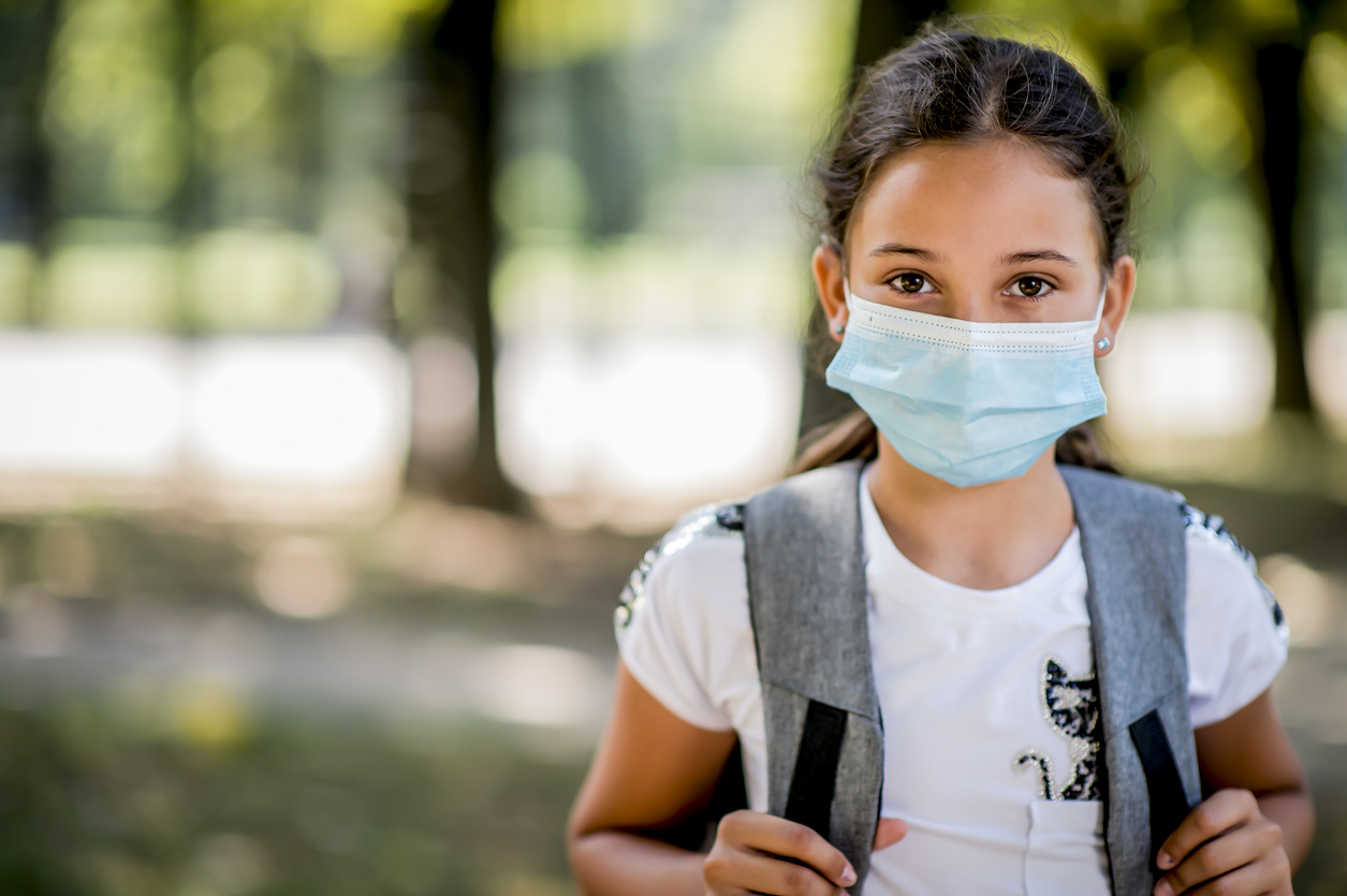 worried girl wearing a backpack and mask
