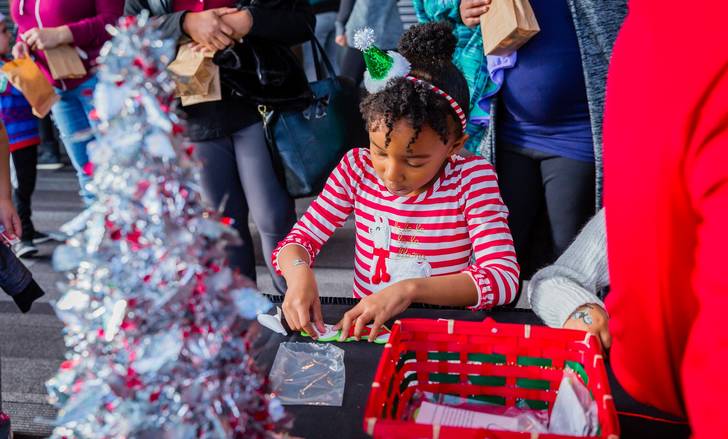 Girl making crafts at Festival of Trees