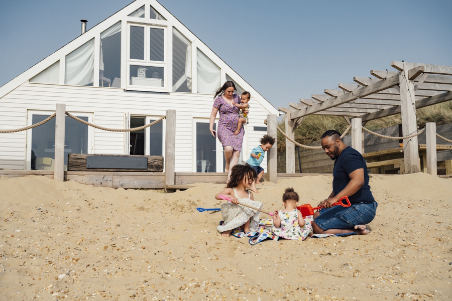 family at a vacation house playing on the beach