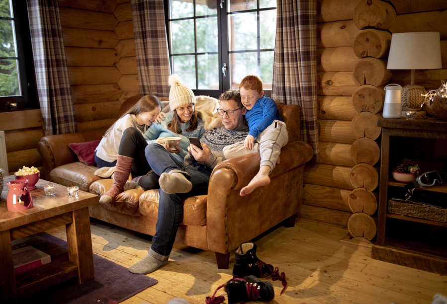 a family in a renal cabin sitting on a couch together happy
