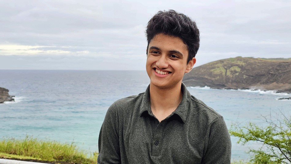 A young man in front of an ocean
