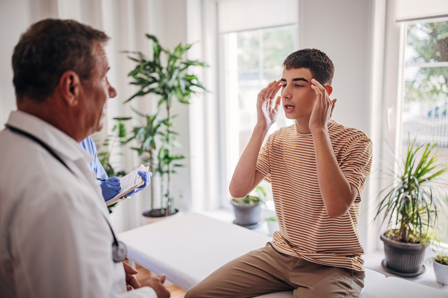 teen boy talking to a doctor about a concussion