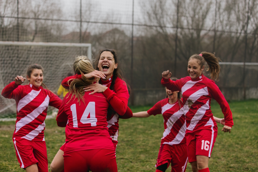girls soccer players celebrating a goal