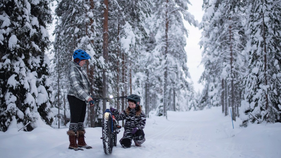 young girl with her mom in the snow on an afternoon fat-biking adventure