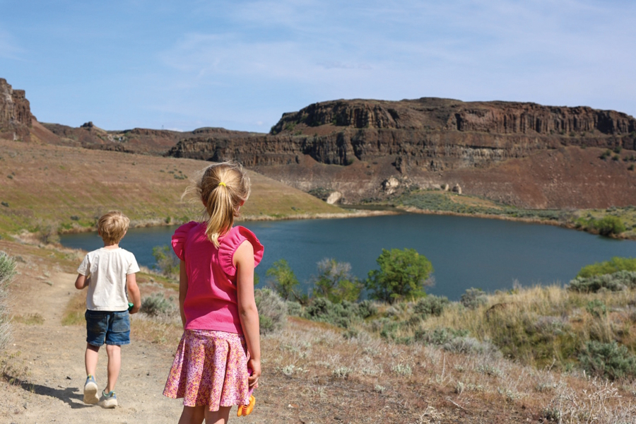 two kids at a lake on a family backpacking trip