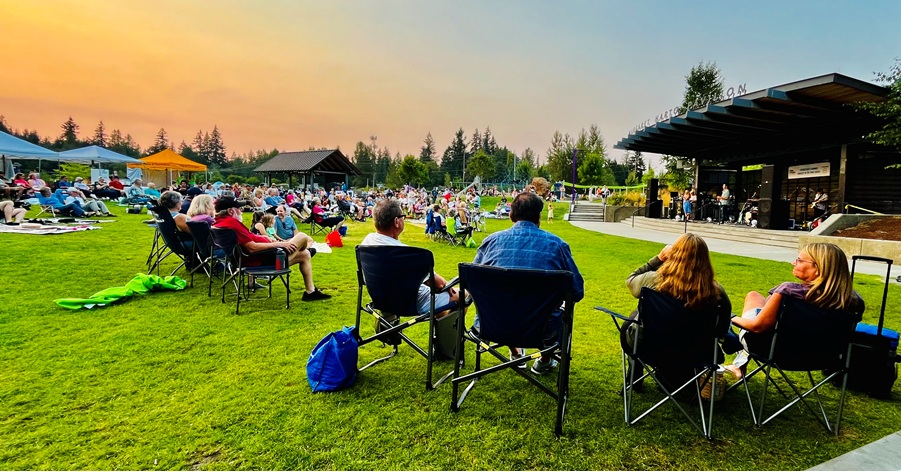 Concert goers set up chairs to enjoy an outdoor summer concert at Covington Community Park.
