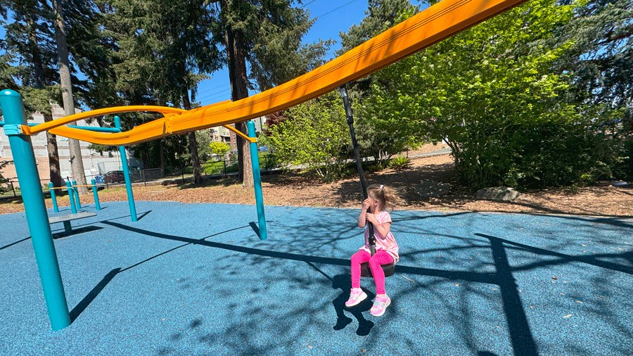 young girl on a zip  line at bitter lake playfield, a new playground in seattle