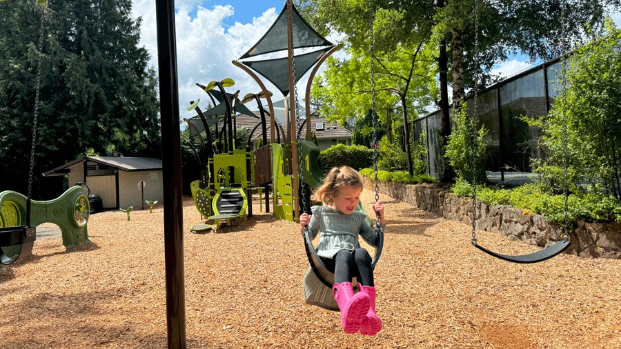 Little girl in pink boots on a swing at Zumdieck Park
