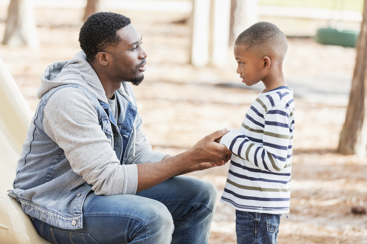 Dad talking with his son and holding his hands