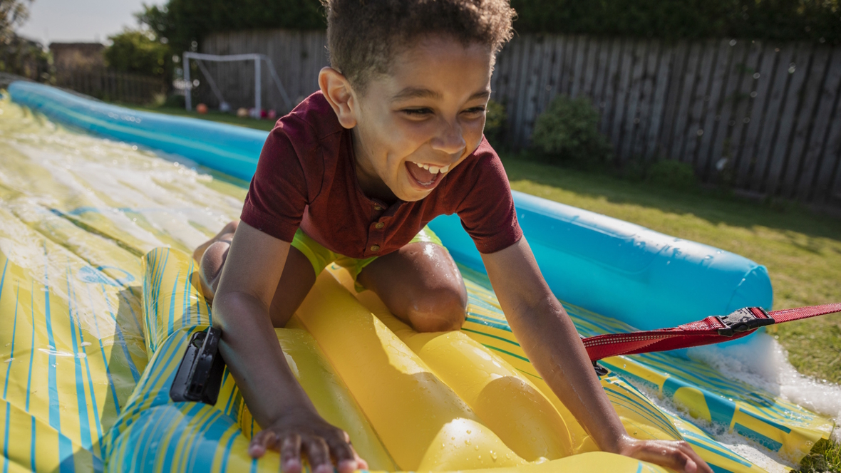 boy on a slip-n-slide backyard epic summer fun
