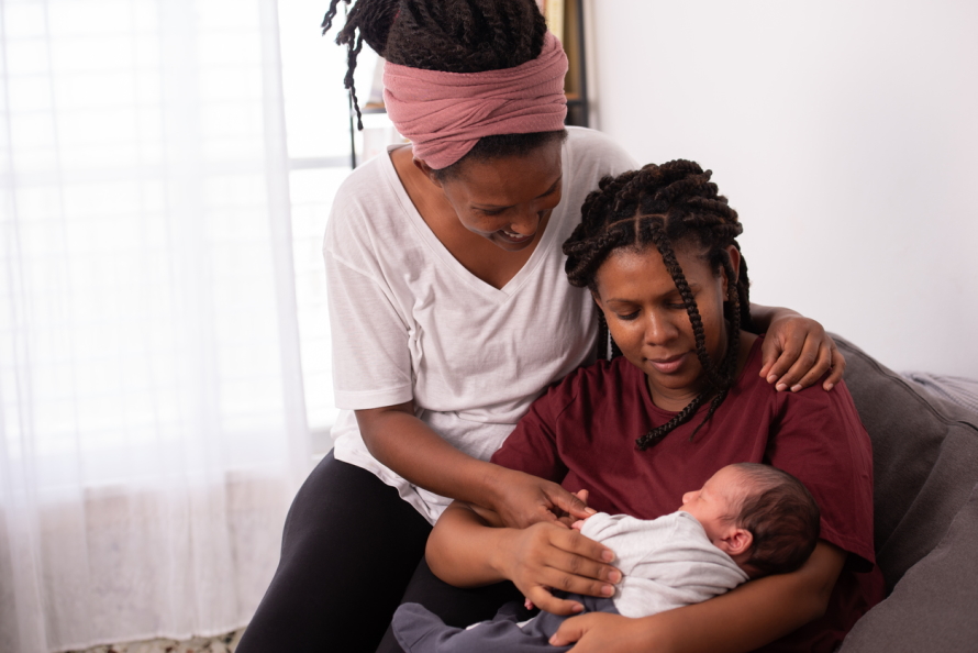 Two moms with their new baby
