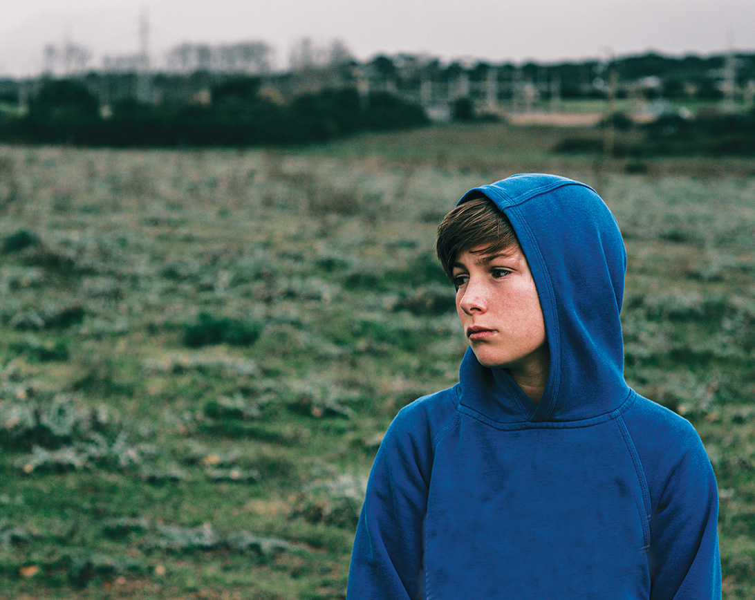 Tween boy wearing a blue hoodie