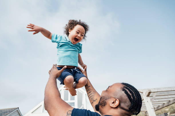 Father playing with a child who is smiling and laughing