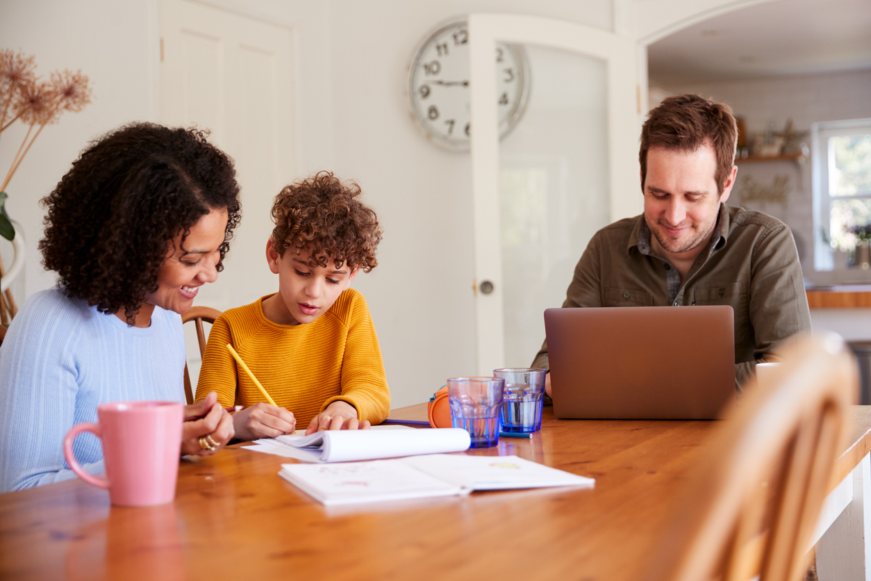 family sitting at the kitchen table working on schoolwork