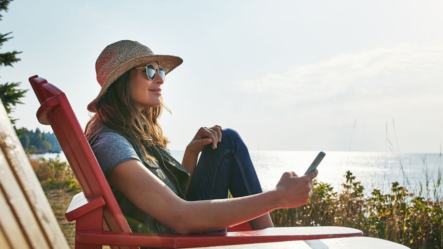 Woman sitting in a chair looking out at a lake on a kid-free vacation