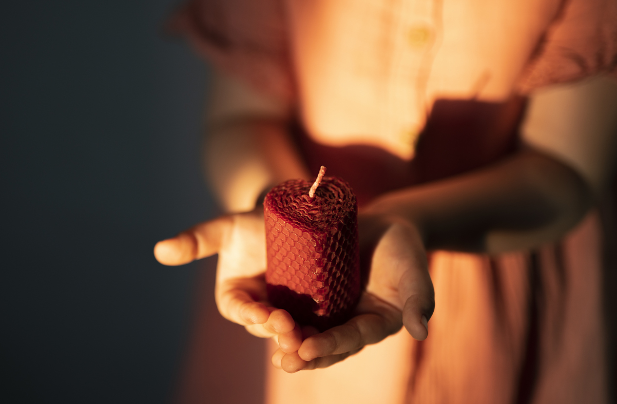a child holds a beeswax candle