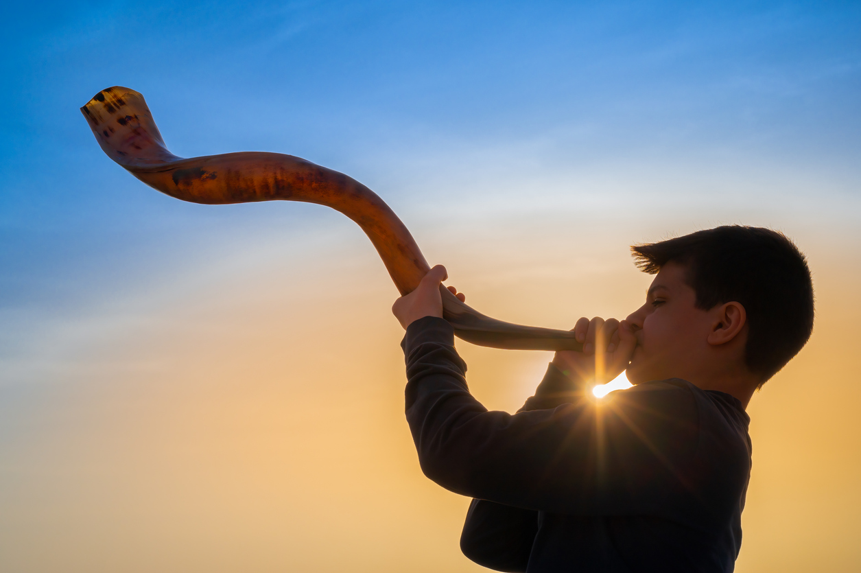 boy blows a Shofar