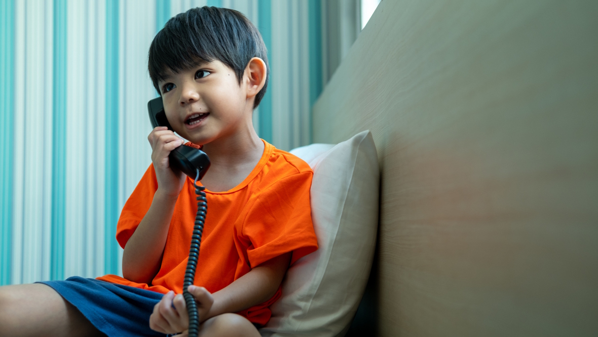 young boy talking on a landline phone