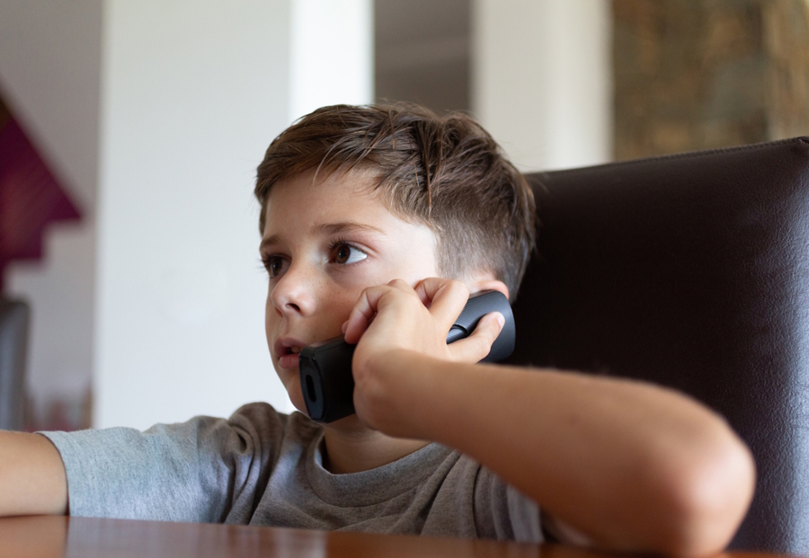 boy calling his friend on a landline phone