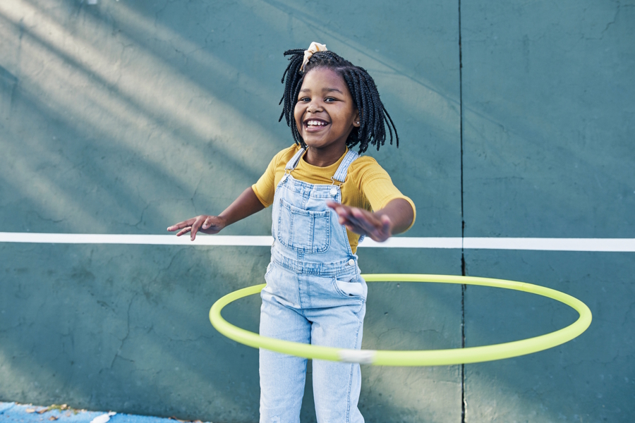 girl playing outside with a hula hoop