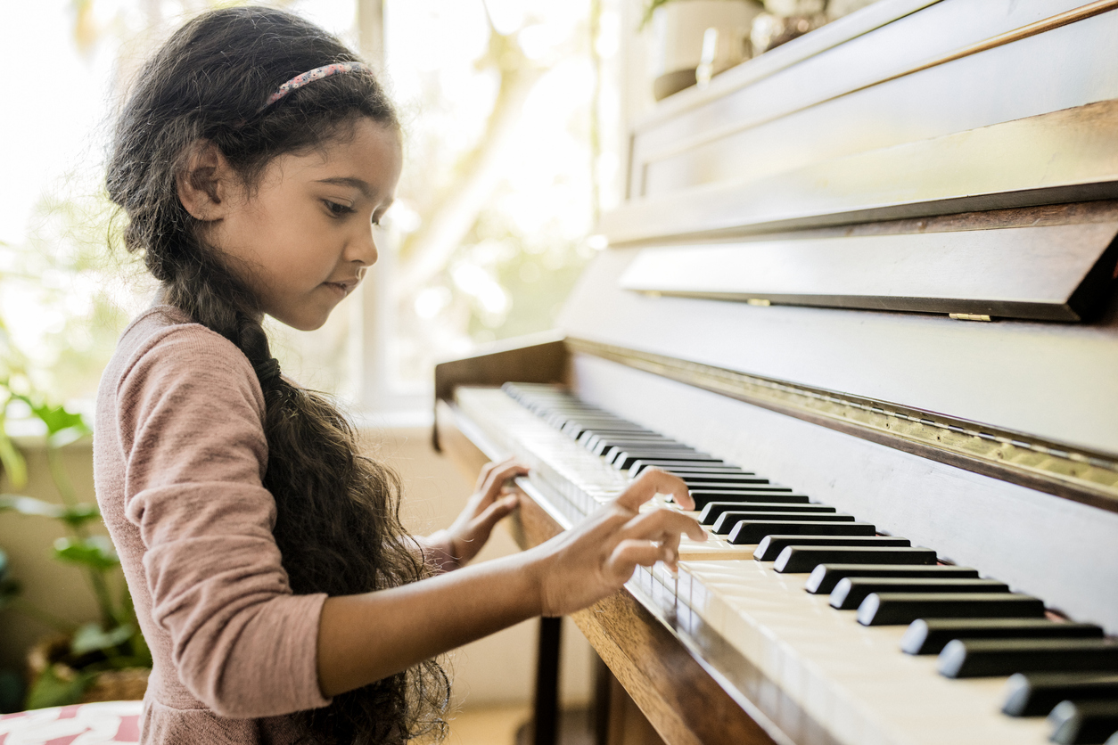 girl playing piano at home