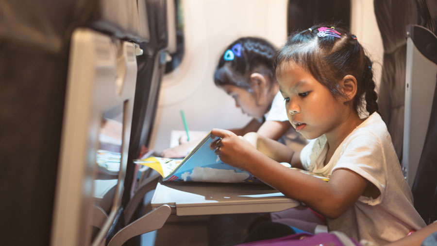 two young girls drawing on an airplane