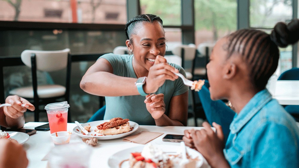 mom feeding child fried chicken from a seattle area restaurant
