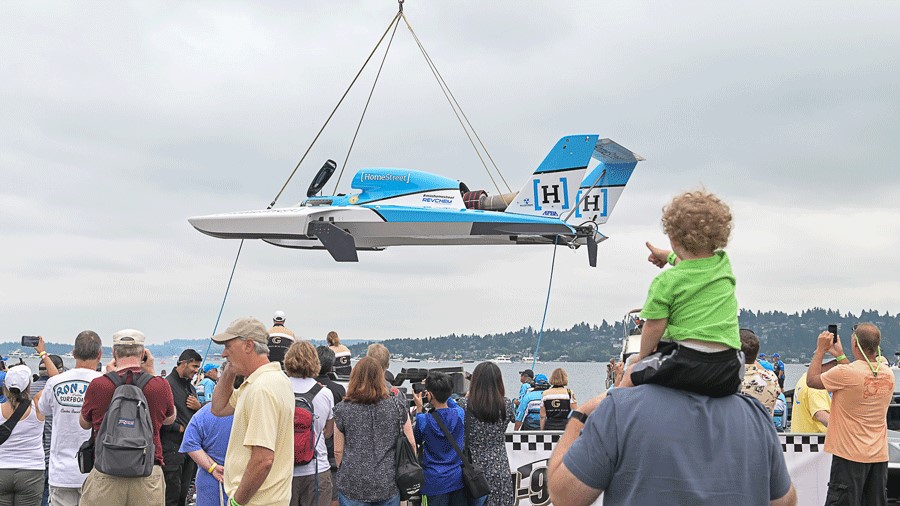A boy sits on his dad's shoulders at family-friendly Seafair, watching the hydroplanes ready to race