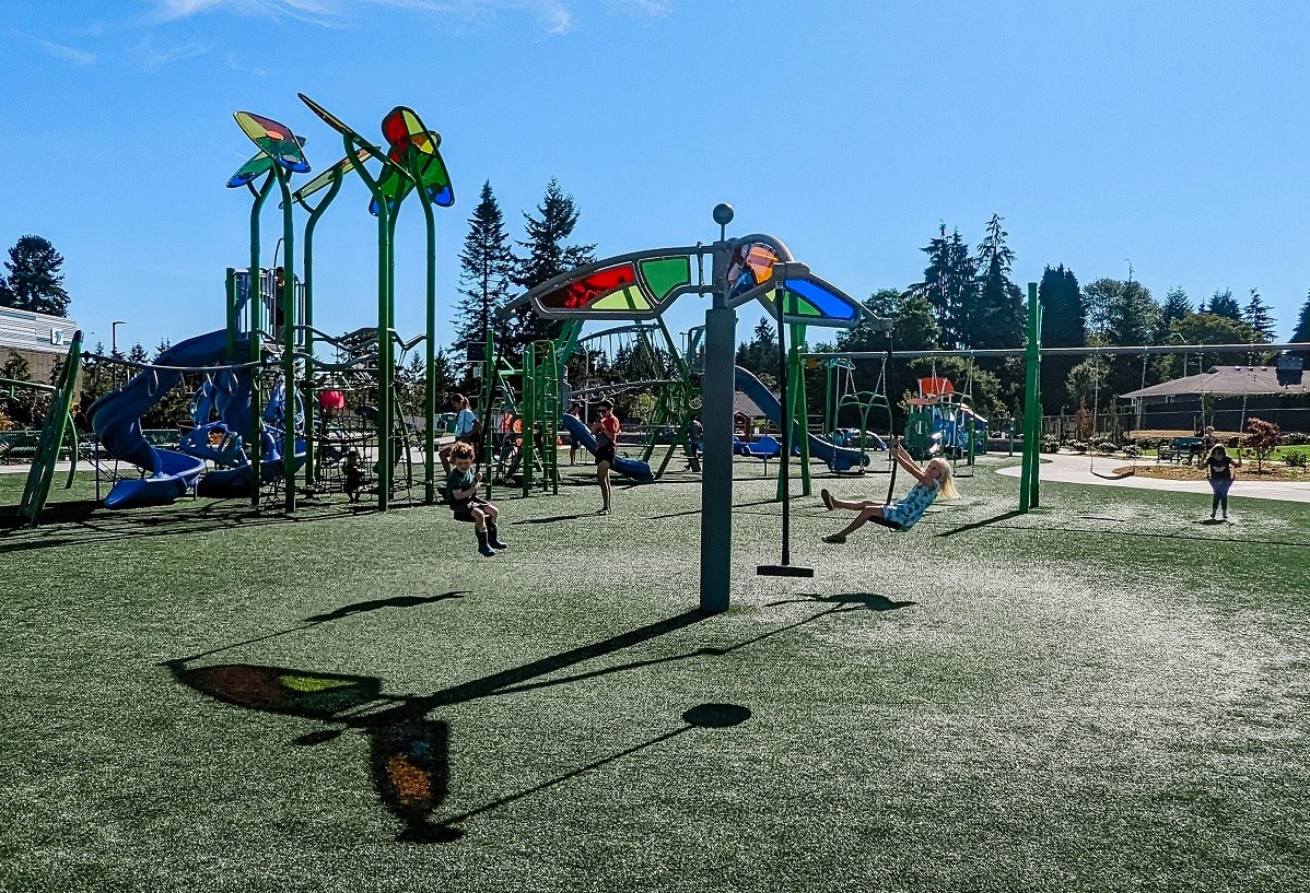 A brother and sister spin on Emma Yule Park’s tri-runner, a three-seat swing spinner