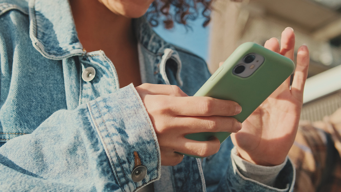 a teen uses a cell phone at school